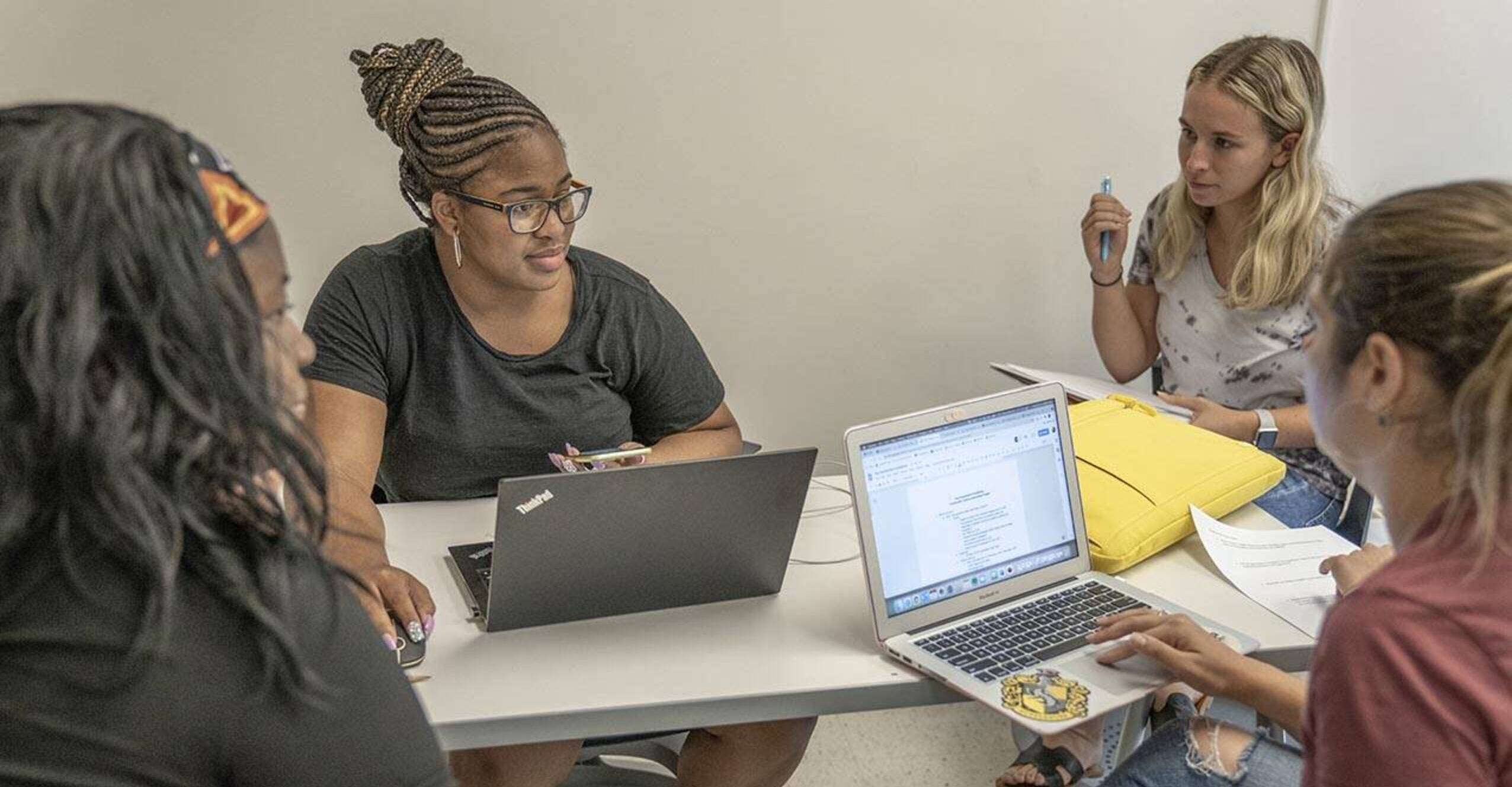 Grad students talking around laptops