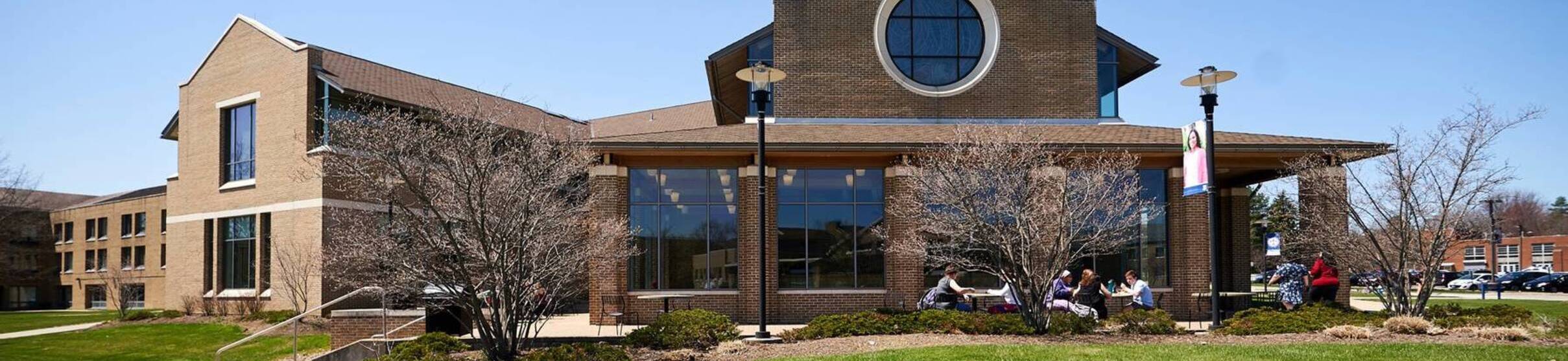 Ursuline college students sit at outdoor tables3